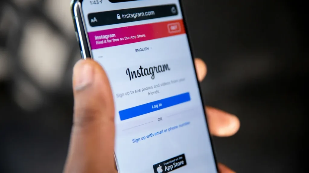 Mão segurando um smartphone com o aplicativo do Instagram aberto na tela